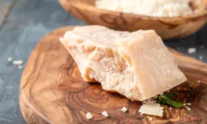 Kawałek twardego sera na desce z oliwnego drewna, idealny jako alternatywa co zamiast parmezanu.