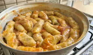 Gołąbki w sosie pomidorowym, gotujące się w garnku. Pyszny sos do gołąbków sprawia, że danie jest aromatyczne i soczyste.