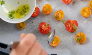 Pomidory pieczone w piekarniku, polane oliwą z ziołami, posypane solą i pieprzem.