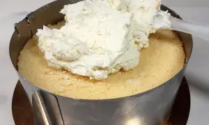 Nakładanie puszystego kremu z mascarpone na biszkopt. Tak właśnie zaczyna się robienie pysznego tortu.