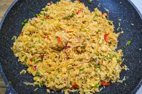 Pyszny ryż smażony z jajkiem, cebulką i papryczką chili, przygotowany w woku.