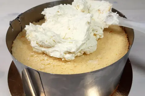 Nakładanie puszystego kremu z mascarpone na biszkopt. Tak właśnie zaczyna się robienie pysznego tortu.