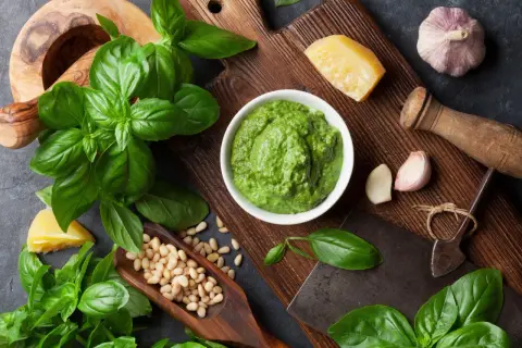 Świeże liście bazylii, orzeszki piniowe, czosnek i parmezan tworzą apetyczne pesto z bazylii.