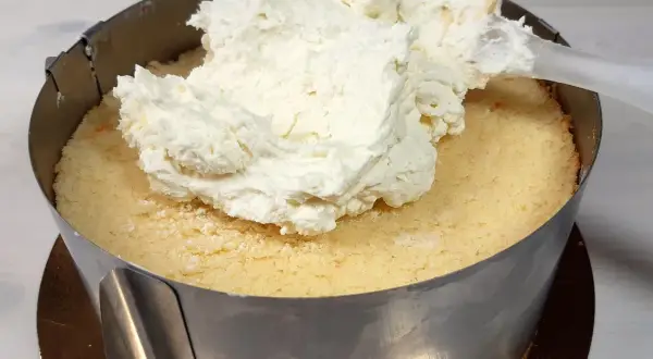 Nakładanie puszystego kremu z mascarpone na biszkopt. Tak właśnie zaczyna się robienie pysznego tortu.