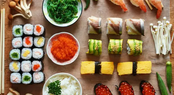 Pyszne sushi: rolki z łososiem, awokado, krewetkami, tamago, ikrą, ryżem i sałatką wakame. Idealne na co do sushi.
