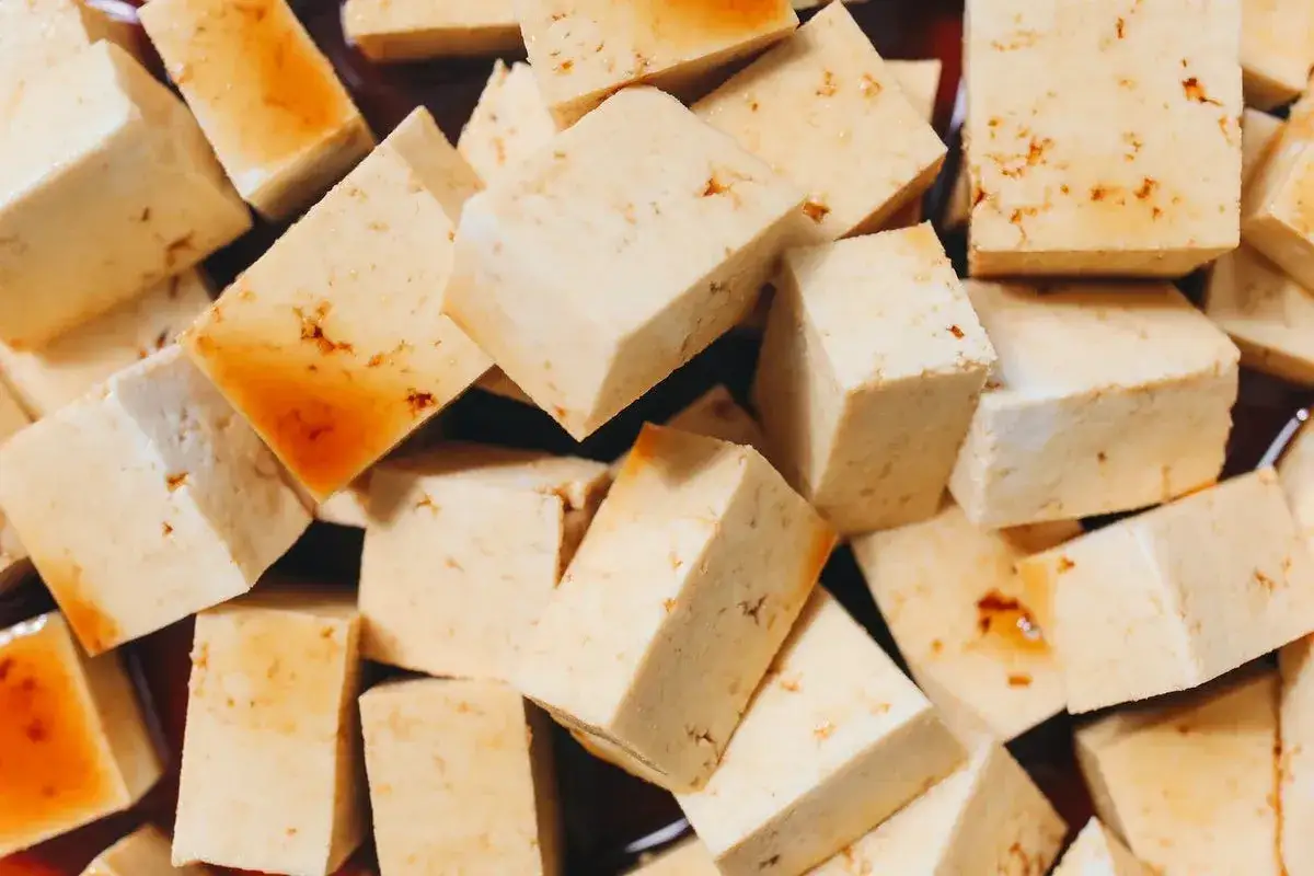 Pokrojone w kostkę tofu, niekt&oacute;re z nich lekko zrumienione, idealne do dań, czy tofu można jeść na surowo? Tak, jest bezpieczne.