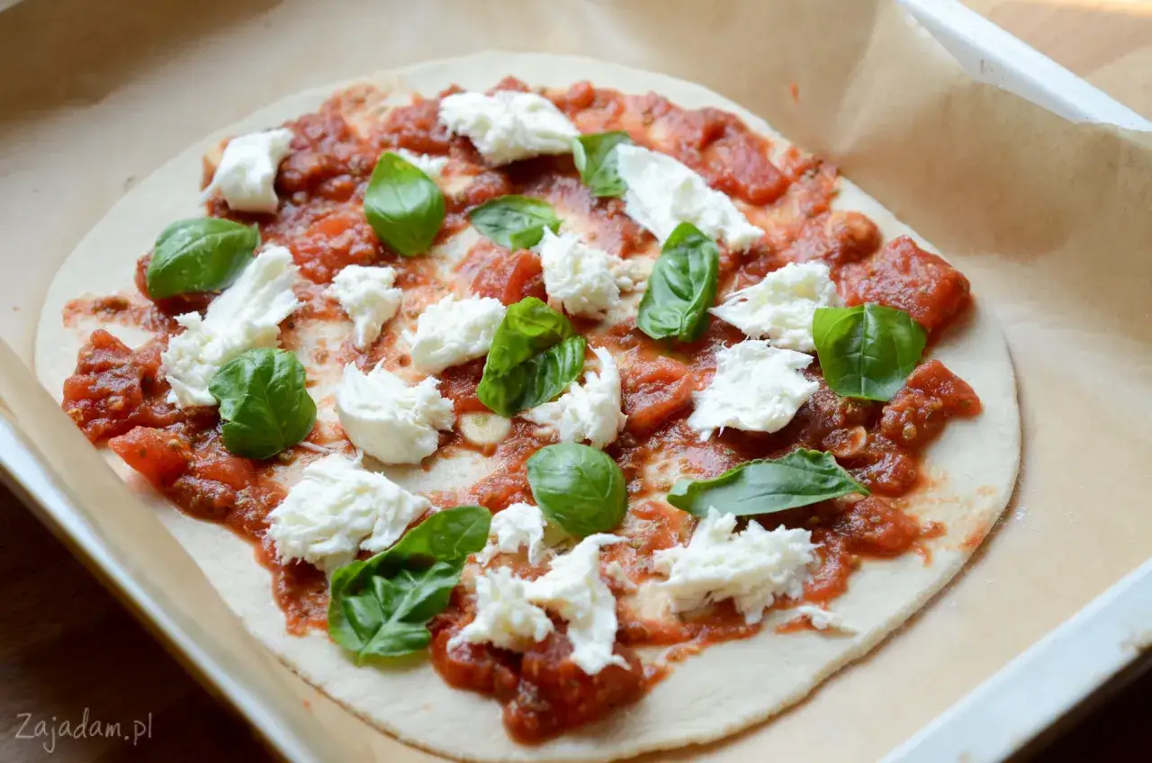Pizza Margherita w przygotowaniu: ciasto, sos pomidorowy, świeża mozzarella i bazylia. Właśnie tak można zrobić pyszną pizzę z mozzarelli!