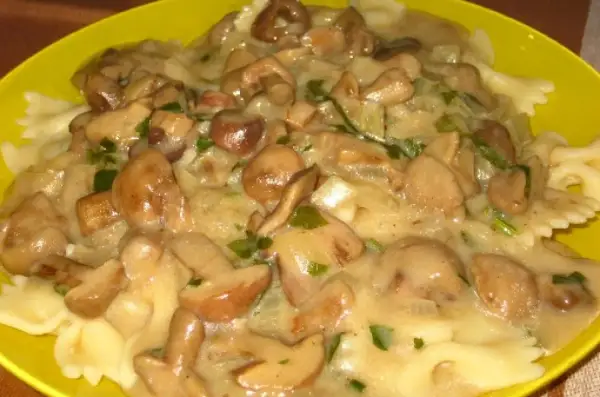 Pyszny makaron farfalle z kremowym sosem z maślaków, cebulą i natką pietruszki. Idealny przepis na to, jak zrobić sos z maślaków.